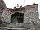 Tibet Kailash 08 Kora 12 Chuku Gompa Outside I crossed the bridge and huffed and puffed uphill through a maze of boulders for 20 minutes to Chuku (or Nyenri) Gompa (4820m), perched high above the valley floor on the hillside to the west. Chuku Gompa was founded by Gtsangpa (1189-1258), a Kagyu disciple, and was the first Kailash Gompa to be rebuilt after the destruction of Cultural Revolution. Inside theres a highly unusual, original marble statue called Chuku Amitabha originally from India and reputed to talk, a silver inlaid conch shell that is said to have flown here from Bodh Gaya, peacock feathers and the tusks of a sacred elephant associated with Padmasambhava, and a large copper pot brought from India by Naropa.